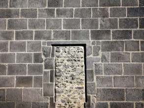 This structure features a stone wall of rough masonry with a distinct doorway outlined in