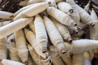 Yarn spindles, spindles, Bramsche, Lower Saxony, Germany, close-up of white yarn spools in a basket