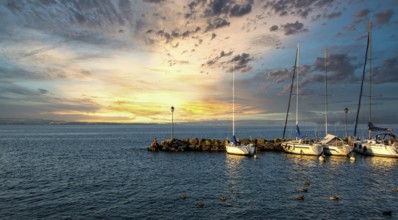 Harbour at Yvoire on Lake Leman during sunset with boats and serene waters in Haute Savoie,
