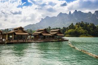 Floating houses on lake with jungle and rainforest and steep mountains, Cheow Lan Lake, Khao Sok