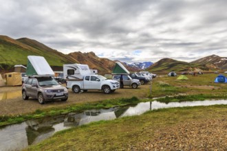 Off-road vehicle with roof tent, camping site in Landmannalaugar, Icelandic highlands, rain clouds,
