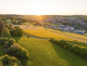 Village at sunset with wide green fields and trees, Gechingen, Black Forest, Germany