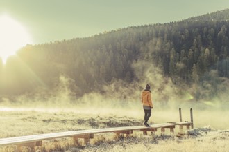 Young woman at Lake Staz near Sankt Moritz in the Engadine in Switzerland. Morning atmosphere with