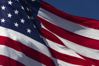 American flag waving in the wind against deep blue sky
