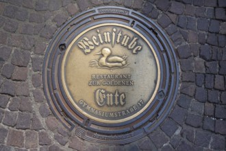Municipal manhole cover with an advert for a wine bar, Biberach an der Riß, Baden-Württemberg,
