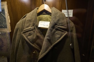 Old British military coat on a hanger in an illuminated wooden display case, War Museum, Military
