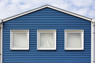 Blue lobster shack, wooden façade with three windows, façade detail in the harbour, Heligoland,