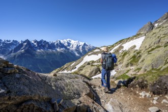 Mountaineer on hiking trail, mountain panorama with glaciated mountain peaks, Aiguille du Midi and