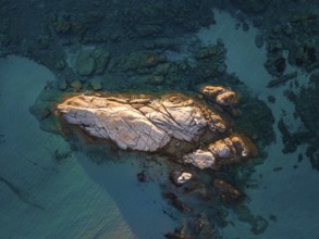 A rock formation rises out of the turquoise-blue water on the Costa Rei, a stretch of coastline on