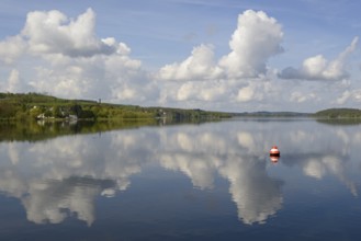 View over the Möhnesee, Möhnesee tower, red and white buoy, blue cloudy sky, reflection on the
