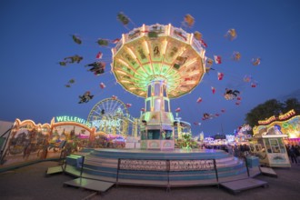 Colourful carousel with light show at a funfair at night, chain carousel, spring festival,