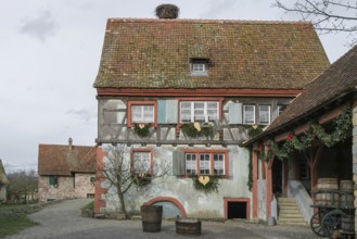 Half-timbered house with colourful paintwork, wooden shutters and rustic charm, surrounded by rural