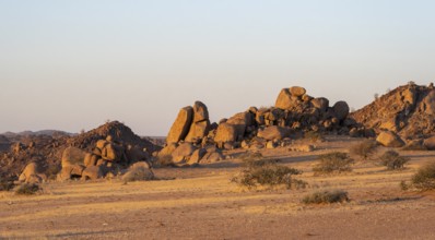 Barren landscape with hills of stacked rocks, desert landscape in the evening light at sunset,