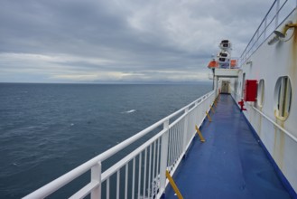 View over the deck of a ferry to the wide sea under a cloudy sky, summer, Cook Strait, North