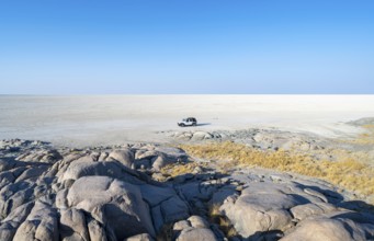 Round rocks of Kubu Island with view over the salt pan, off-road vehicle on the salt pan, Kubu