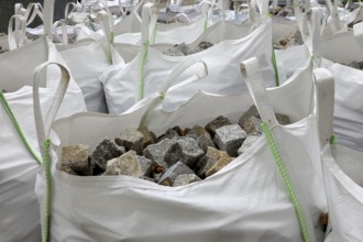 Building site, road construction, granite paving stones packed in big packs, cobblestones