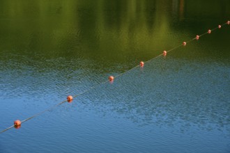 Row of red buoys on calm, green-blue water, summer, Rursee, Rurberg, Simmerath, Eifel National