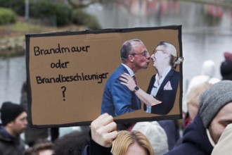 Friedrich Merz kisses Alice Weidel, banner on the topic of the firewall, demonstration against