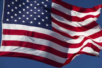 American flag waving in the wind against deep blue sky