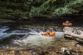 Visitors tubing down Deep Creek in the Smoky Mountains near Bryson City, North Carolina, USA