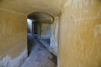 Long corridor with weathered walls leading into the darkness, mysterious and abandoned, Italian