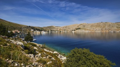 Coast with blue water and hilly landscape under a clear sky, Bay of Emporio, Emporio, Symi,
