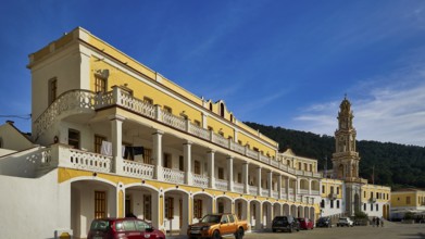 Yellow building with balconies, vehicles in front, blue sky in the background, Holy Week, Bay of