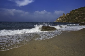 Sea crashing against rocks on the beach under a clear blue sky, Ricadi, Capo Vaticano