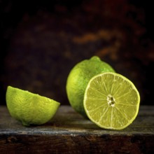Close-up view of fresh lemons and their slices set against a brown background, showcasing the