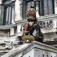 Venetian costume with mask, disguised person posing, carnival in Venice, Italy