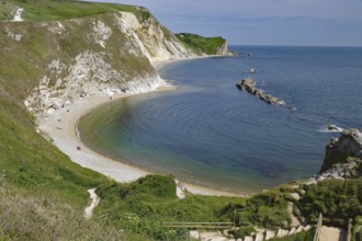 Curved coastline with sandy beach and cliffs, calm sea, Durdle Door, Weymouth, Dorset, England,