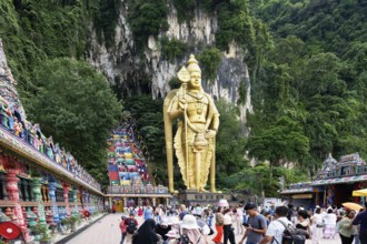 Murugan statue the God of War and colorful staircase leading to the caves with many pilgrims, Batu