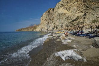 Calm beach with gentle waves in front of high cliffs and clear sea, Embros Thermen, Kos,