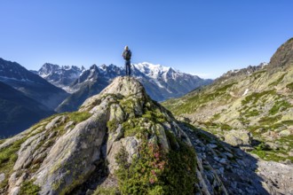 Mountaineer on a rock, mountain panorama with glaciated mountain peaks, Aiguille du Midi and Mont
