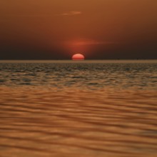 When the red sun sinks into the sea... Cuxhaven, North Sea, sunset in calm weather, glowing red