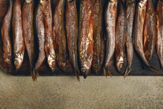 Cold smoked capelin, on a wooden chopping board, no people