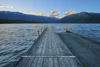Wooden jetty at the lake with mountains at dusk and clouds, summer, Lake Rotoiti, Saint Arnaud,