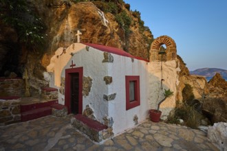 Legend, crab, shell fisherman, rock embedded chapel with cross and bell arch, surrounded by coastal