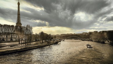 Under a dramatic sky, the Eiffel Tower stands tall beside the river Seine. Boats glide along the