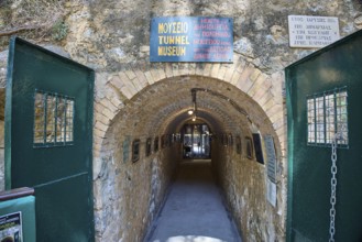 Entrance to a tunnel museum with green doors and several signs, War Museum, Military Museum, Tunnel