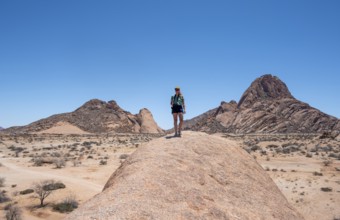 Tourist with camera, rock formation, Pontok Mountains, Spitzkoppe, Große Spitzkuppe Nature Reserve,