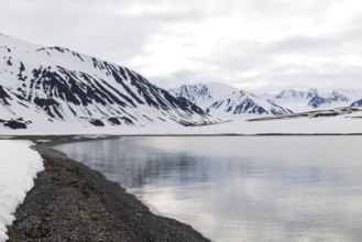 Pebble beach in a bay, mountain range, snow, Mushamna, Spitsbergen, Svalbard