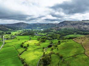 Farms and Mountains over road A591 from a drone, Grasmere Lake, Grasmere, Ambleside, Lake District,
