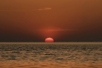 When the red sun sinks into the sea... Cuxhaven, North Sea, sunset in calm weather, glowing red