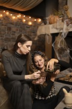 Two friends are seated together in a warm and inviting room, engaging in a joyful moment as one