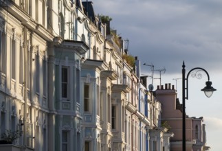 Street lamp, terraced houses, townhouses with different, partly pastel-coloured facades Portobello
