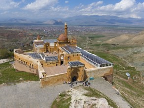 Aerial view of an old fortification with visitors, embedded in green mountain landscape, Ishak