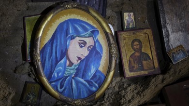 Portrait of Mary in blue in an oval frame, surrounded by smaller icons and religious depictions,