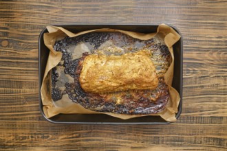 Overhead view of roasted pork neck in a baking tray