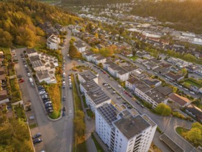 Residential area with streets and buildings in the evening light, surrounded by green nature,